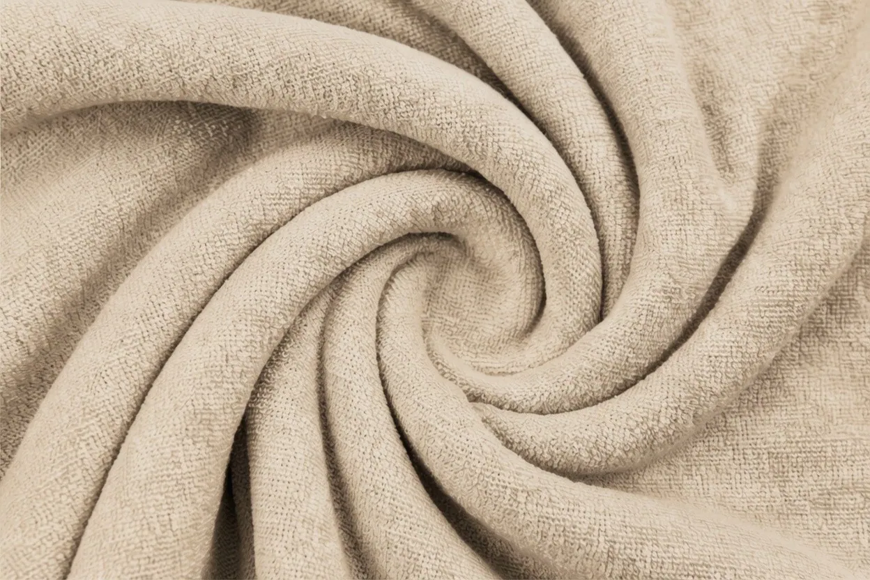 Terry cloth knit fabric in pale stone cotton with looped pile surface, manufactured at Apex Corporation knitwear factory in Karachi Pakistan
